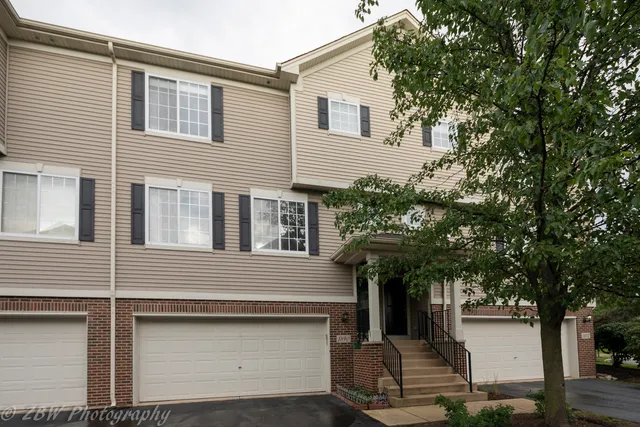 a front view of a house with a tree