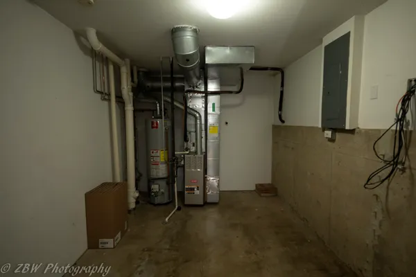 a water heater room with a refrigerator