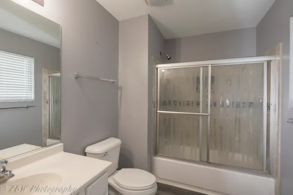 a white toilet next to a bathroom