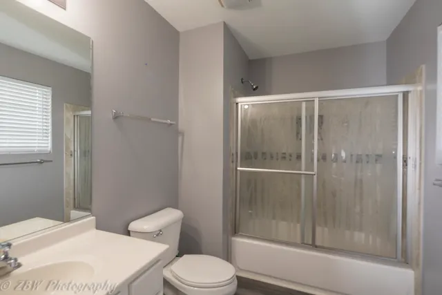 a white toilet next to a bathroom