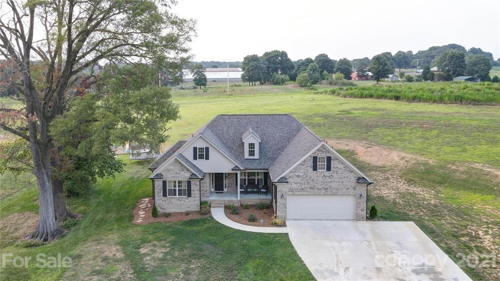 5801 Sikes Mill Road Monroe, NC 28110 - Photo 2 of 41 a aerial view of a house next to a big yard and large trees