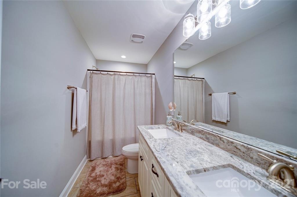 5801 Sikes Mill Road Monroe, NC 28110 - Photo 34 of 41 a bathroom with a granite countertop sink a mirror and shower