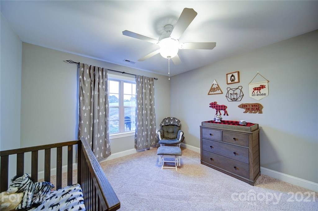 5801 Sikes Mill Road Monroe, NC 28110 - Photo 36 of 41 a bedroom with a bed and a chandelier