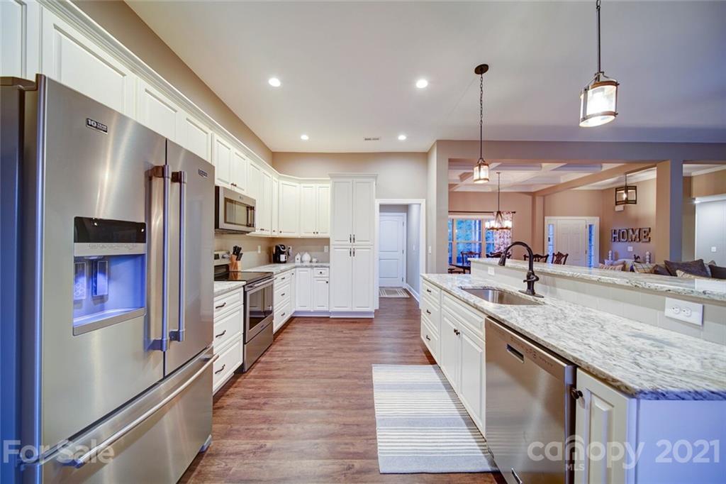 5801 Sikes Mill Road Monroe, NC 28110 - Photo 5 of 41 a large kitchen with stainless steel appliances kitchen island granite countertop a large kitchen island a stove a refrigerator a oven and a sink with large countertops