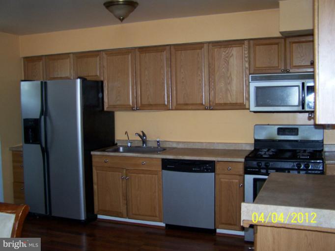 8704 Geren Road Silver Spring, MD 20901 - Photo 4 of 15 a kitchen with stainless steel appliances granite countertop a stove a refrigerator and a microwave