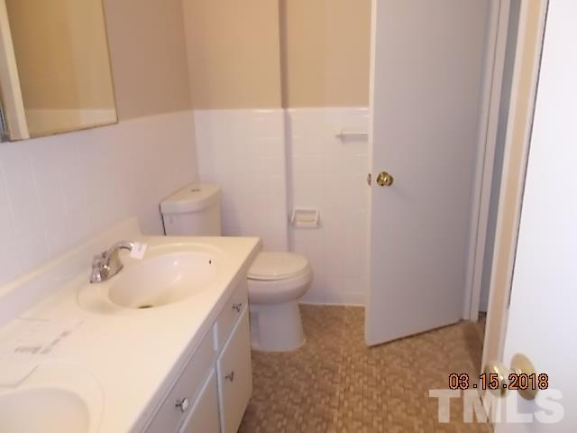 3933 Buffaloe Road Raleigh, NC 27604 - Photo 11 of 16 a bathroom with a sink and mirror with toilet