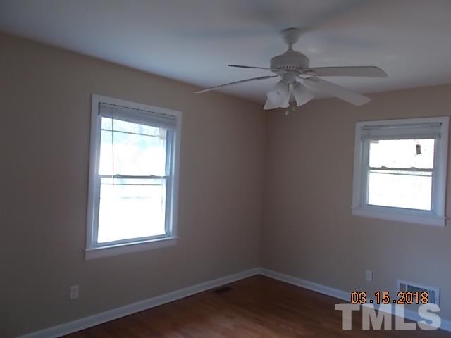 3933 Buffaloe Road Raleigh, NC 27604 - Photo 12 of 16 an empty room with a window and a fan