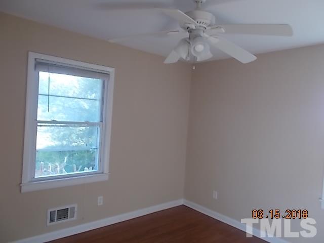 3933 Buffaloe Road Raleigh, NC 27604 - Photo 13 of 16 an empty room with a window and a chandelier fan