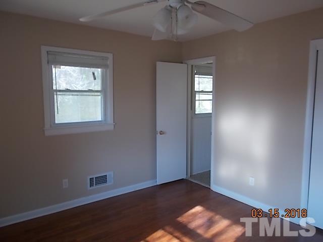 3933 Buffaloe Road Raleigh, NC 27604 - Photo 15 of 16 an empty room with wooden floor and windows