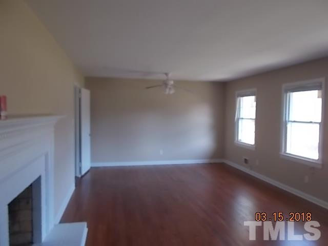 3933 Buffaloe Road Raleigh, NC 27604 - Photo 7 of 16 an empty room with windows and fireplace