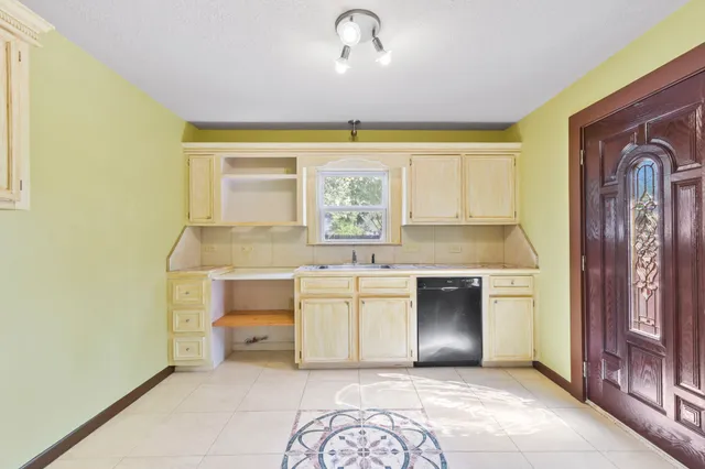 a kitchen with a stove a sink and a window