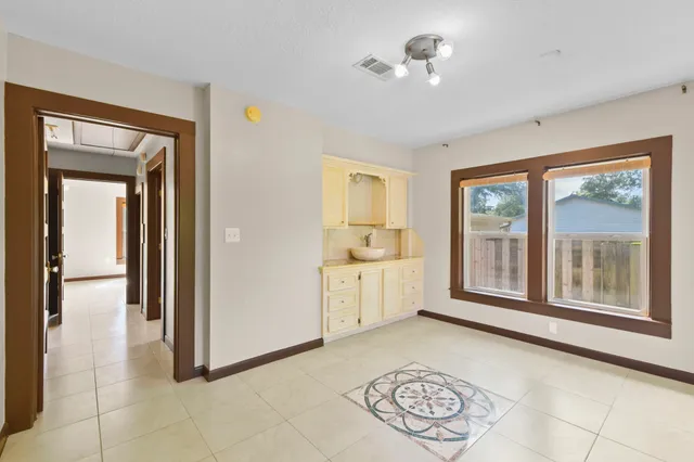 a view of a hallway with windows and chandelier