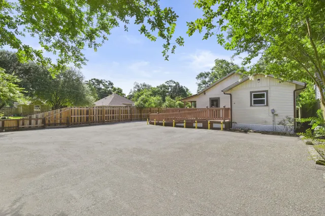 a view of an house with backyard and a tree