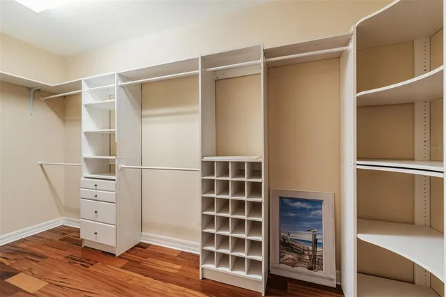 a kitchen with stainless steel appliances granite countertop a stove top oven a refrigerator a sink and a dining table with wooden floor