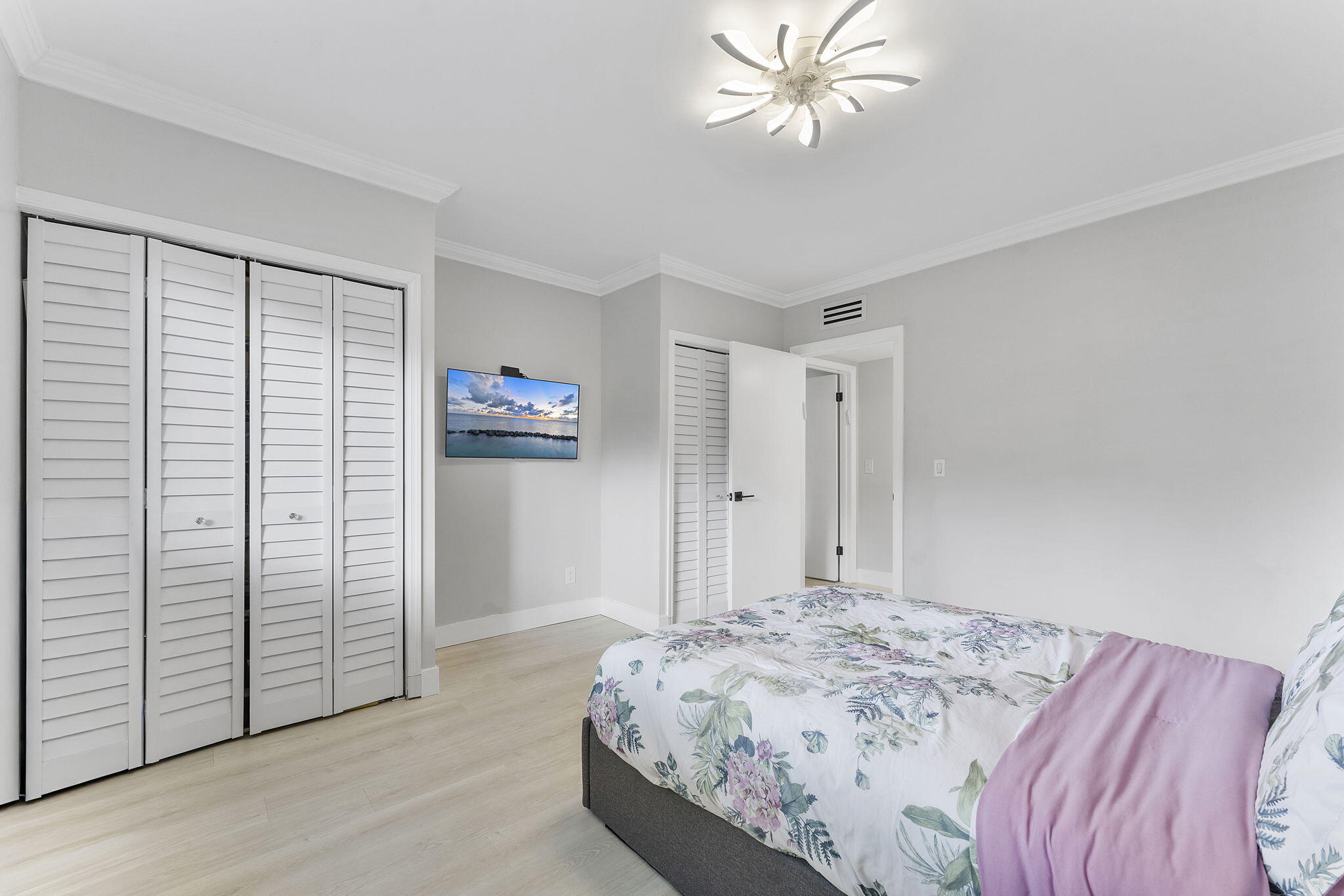 6314 Longboat Lane West, Unit 102 Boca Raton, FL 33433 - Photo 19 of 24 a bedroom with a bed and a chandelier