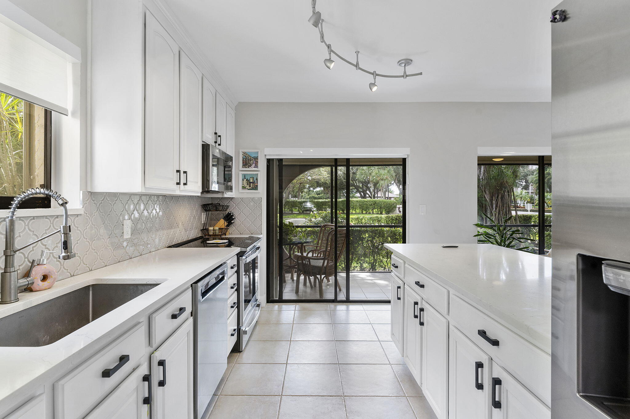 6314 Longboat Lane West, Unit 102 Boca Raton, FL 33433 - Photo 5 of 24 a kitchen with a sink and a refrigerator