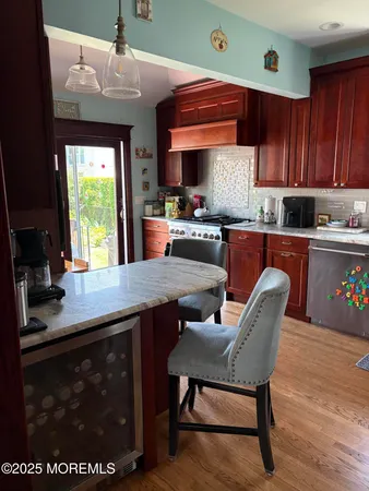 a kitchen with granite countertop a stove a sink dishwasher and cabinets with wooden floor