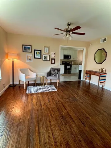 a living room with furniture and a wooden floor