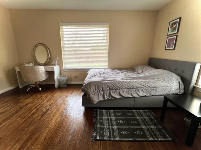 a bedroom with a bed chair and a window