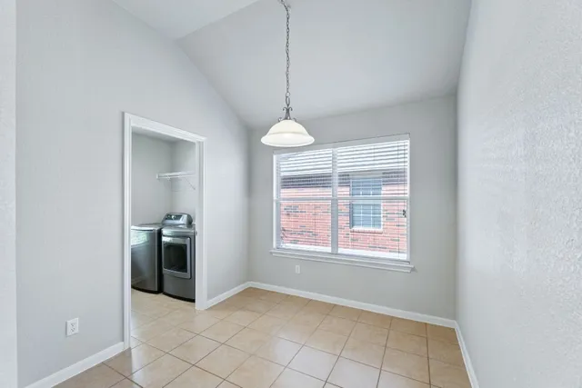 a view of an empty room with window and cabinet