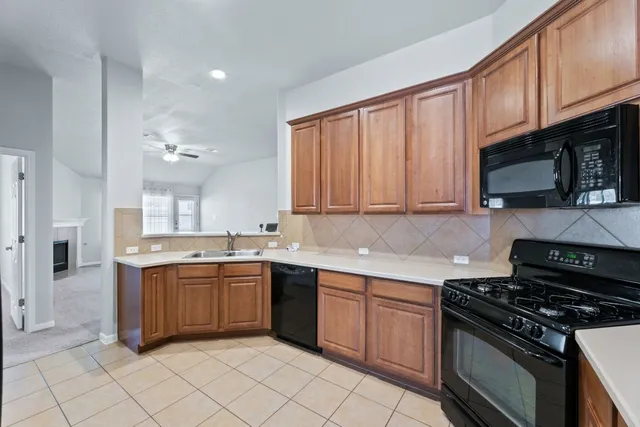 a kitchen with stainless steel appliances granite countertop a stove top oven a sink dishwasher and granite countertops