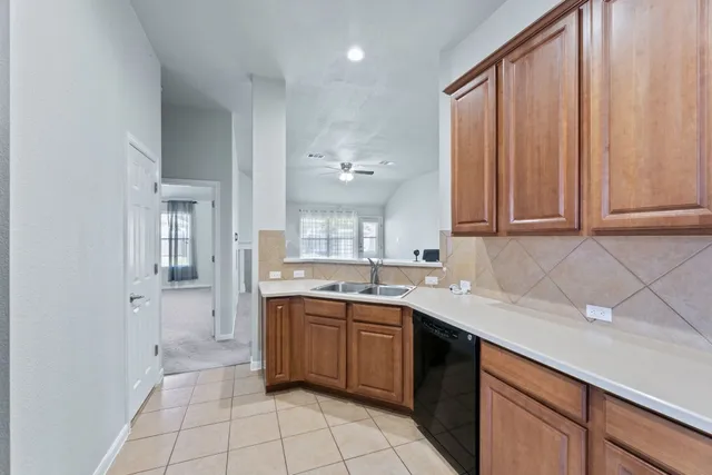 a kitchen with a sink dishwasher and cabinets