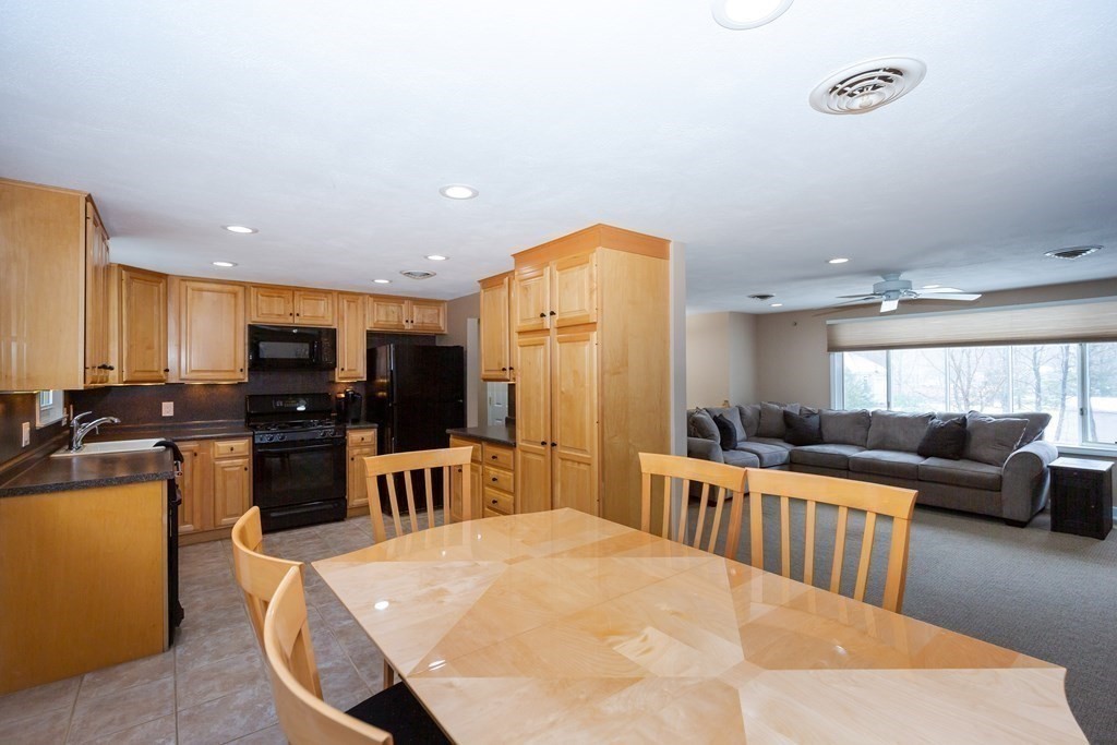 5 Williams Road Sharon, MA 02067 - Photo 5 of 34 a kitchen with stainless steel appliances kitchen island granite countertop a refrigerator a stove a microwave oven with a dining table and chairs