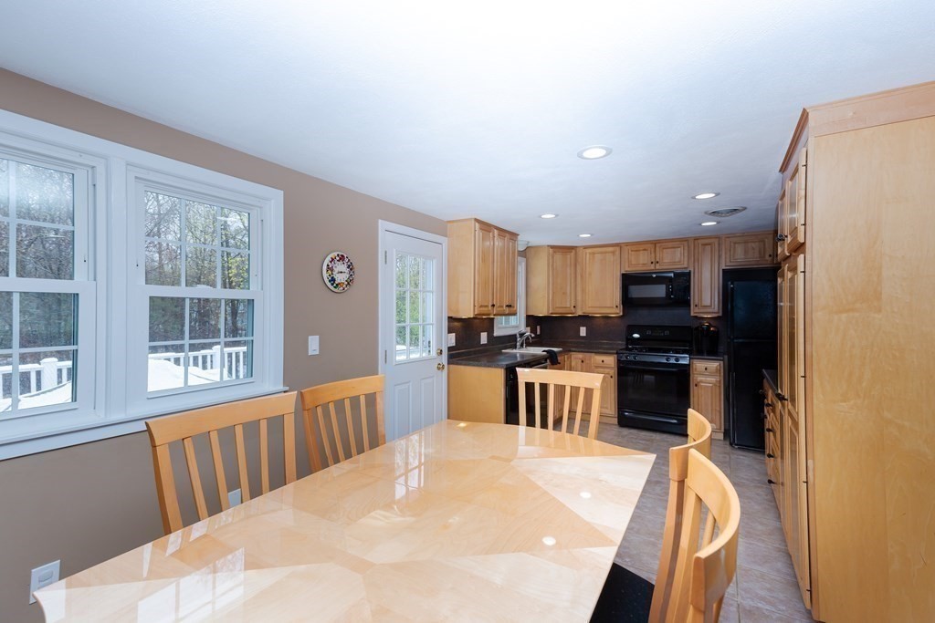 5 Williams Road Sharon, MA 02067 - Photo 9 of 34 a kitchen with stainless steel appliances kitchen island granite countertop a refrigerator a stove a sink a dining table and chairs with wooden floor
