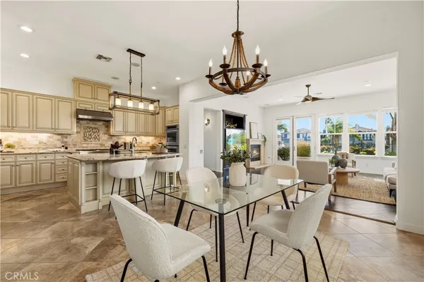 a kitchen with stainless steel appliances granite countertop a sink a stove a dining table and chairs with wooden floor