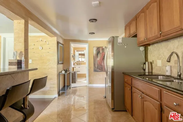 a kitchen with stainless steel appliances granite countertop a refrigerator and a sink