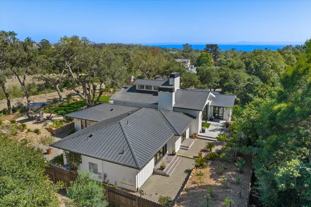 an aerial view of a house with a yard and mountain view in back