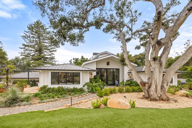 a front view of a house with a yard and trees
