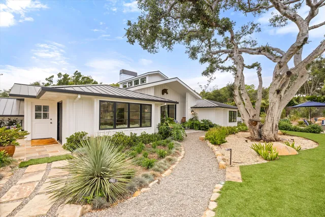 a front view of house with yard and trees around