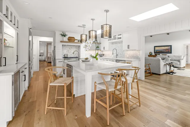 a kitchen with stainless steel appliances a dining table chairs and granite counter tops