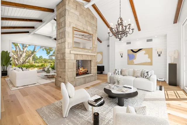 a living room with furniture a fireplace and a chandelier