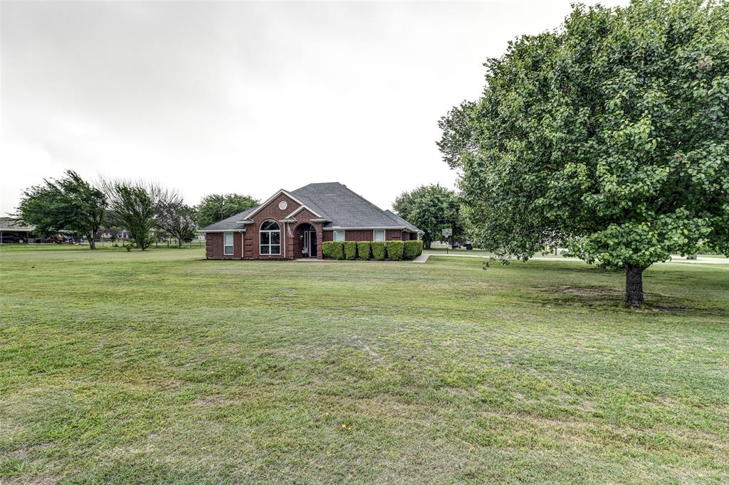 251 Mockingbird Lane Decatur, TX 76234 - Photo 1 of 1 a white house with a big yard and large trees