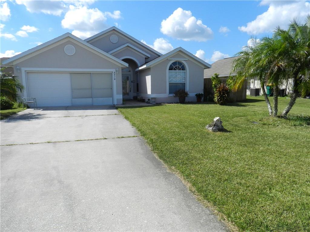 2710 Eagle Ridge Loop Kissimmee, FL 34746 - Photo 1 of 1 a front view of a house with a yard and garage