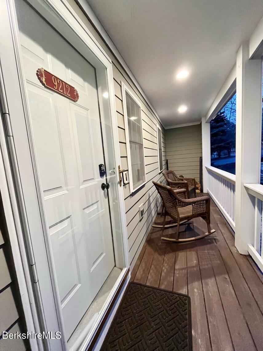 a balcony with chairs and wooden floor