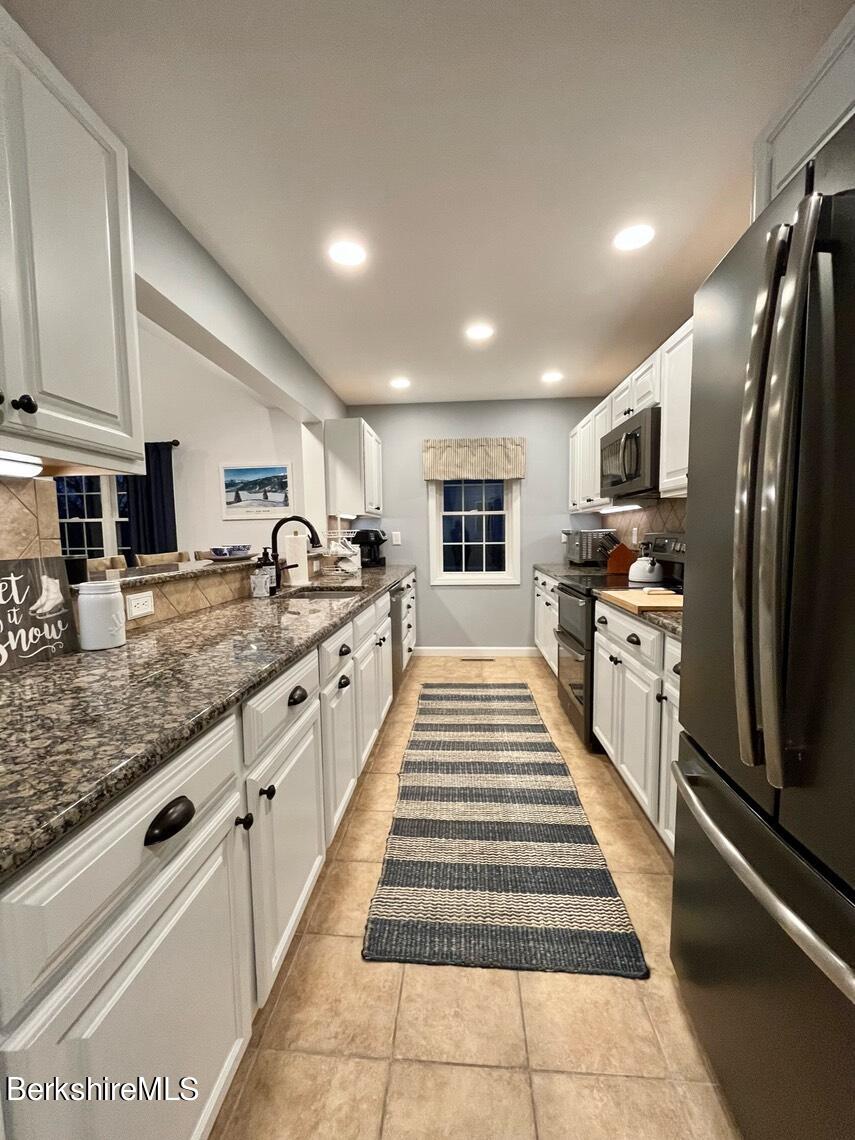 9212 Mountainside Drive Hancock, MA 01237 - Photo 18 of 44 a large kitchen with stainless steel appliances kitchen island granite countertop a large stove top oven and cabinets
