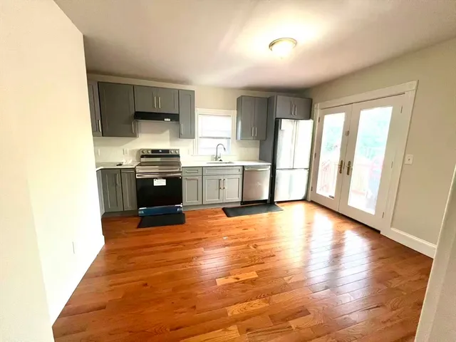 a view of a kitchen with wooden floor and electronic appliances