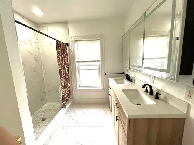 a bathroom with a sink a mirror and a shower