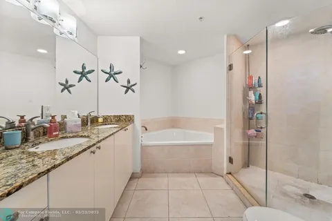 a bathroom with a granite countertop sink a mirror and a bathtub