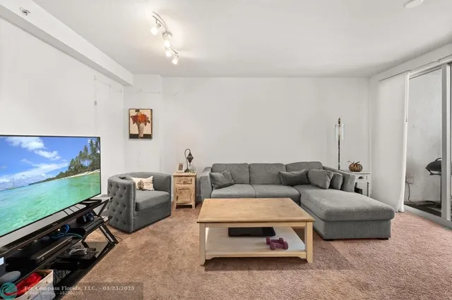 a living room with furniture a flat screen tv and a bookshelf