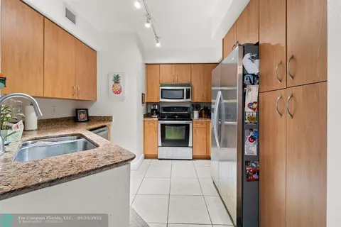 a kitchen with granite countertop a refrigerator and a sink