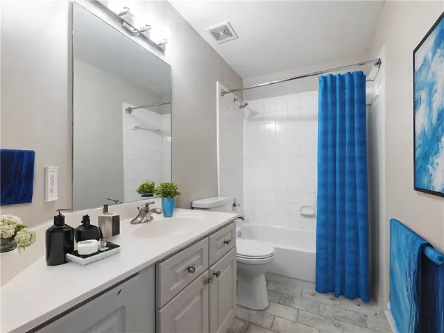 a bathroom with a double vanity sink toilet and shower