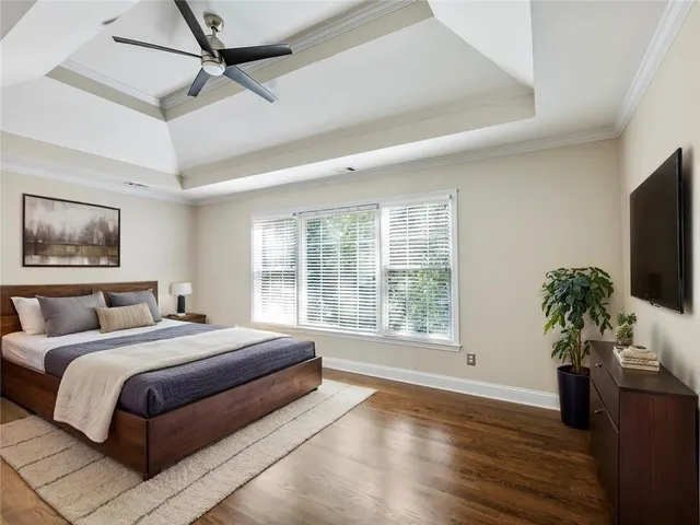 a spacious bedroom with a large bed and a flat screen tv