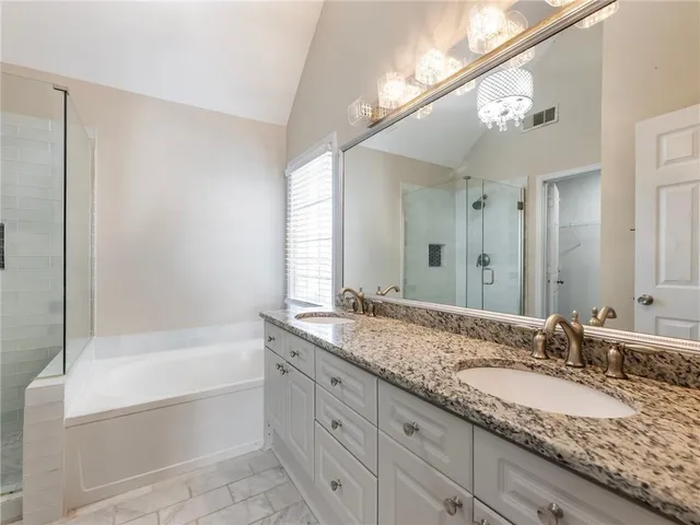 a bathroom with a granite countertop sink mirror and bathtub
