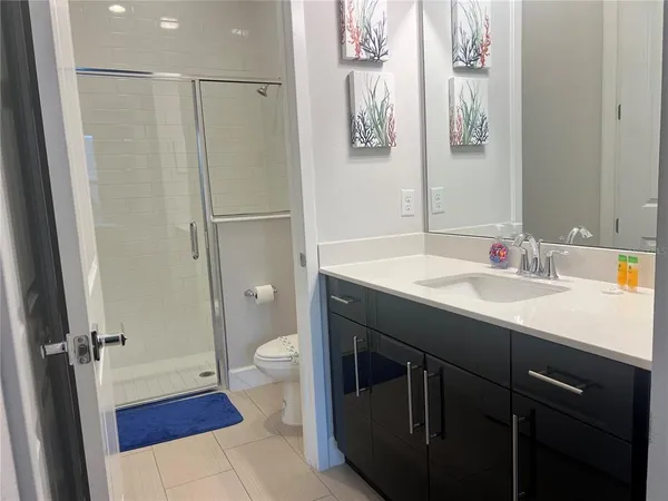 a bathroom with a sink a toilet a mirror and shower