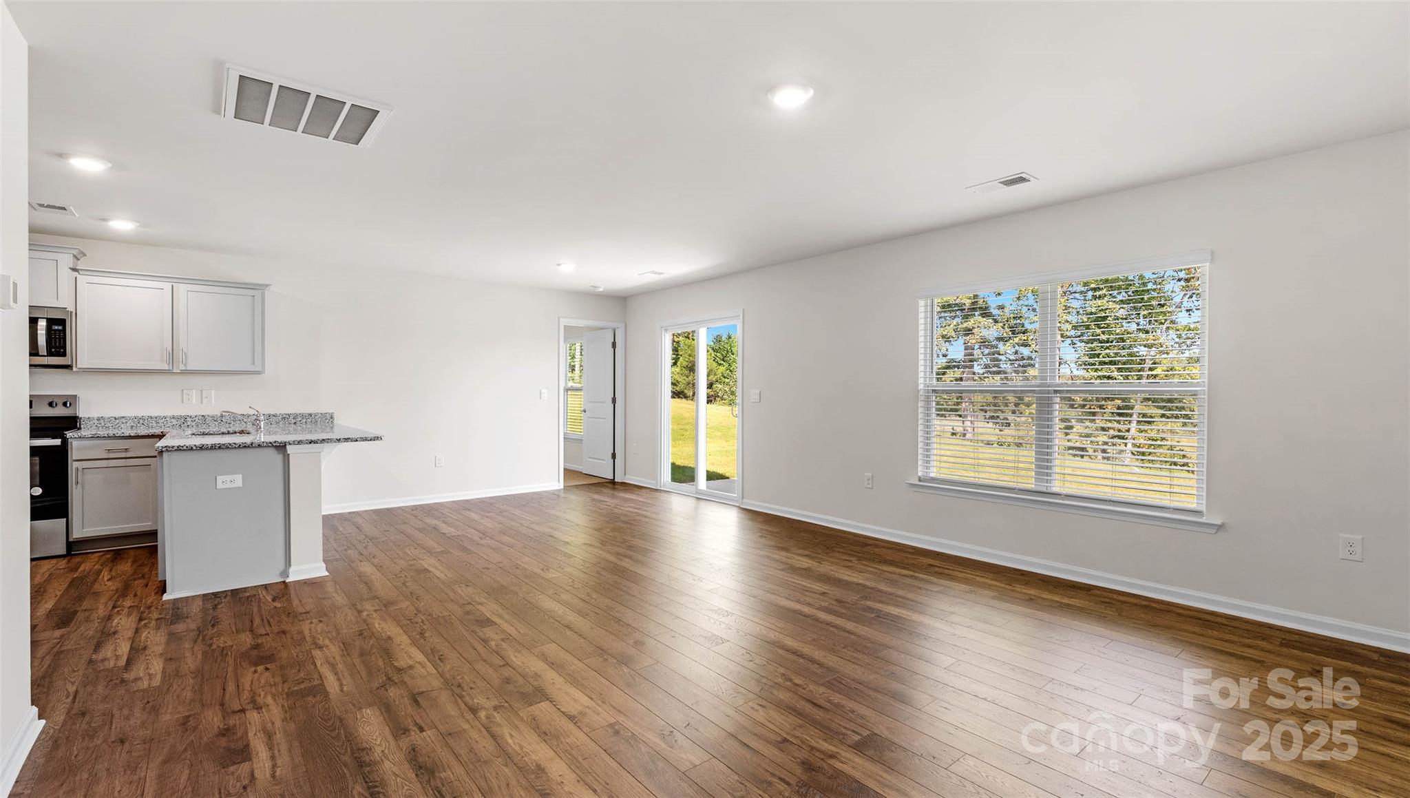 382 Wheatfield Road Fletcher, NC 28732 - Photo 8 of 24 a view of an empty room with window and wooden floor