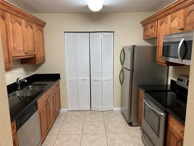 a kitchen with stainless steel appliances granite countertop a refrigerator stove and sink